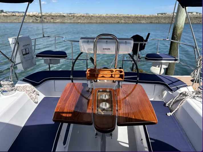Sea Urchin Yacht Photos Pics Cockpit of 2013 Catalina 355 sailboat with wooden table and steering wheel, docked by the water.