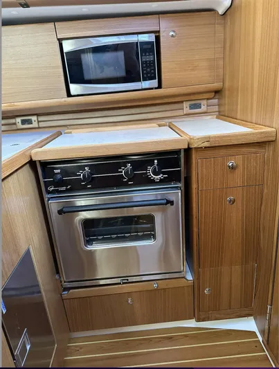 Sea Urchin Yacht Photos Pics Catalina 355 2013 yacht kitchen with microwave and oven, featuring wooden cabinetry.