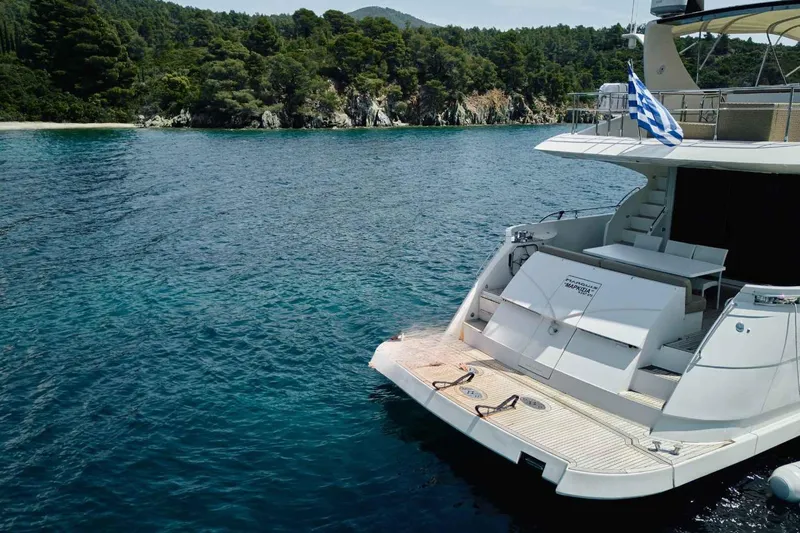 Markisia Yacht Photos Pics Luxury Marquis 720 Flybridge yacht, 2010 model, anchored near a scenic forested coastline.