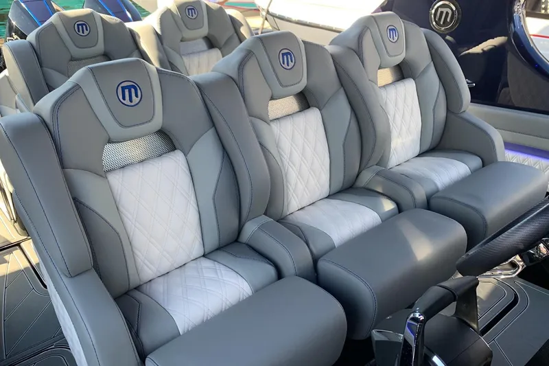 Yacht Photos Pics Luxurious seating in 2026 Mystic Powerboats M3800, featuring elegant gray and white upholstery.