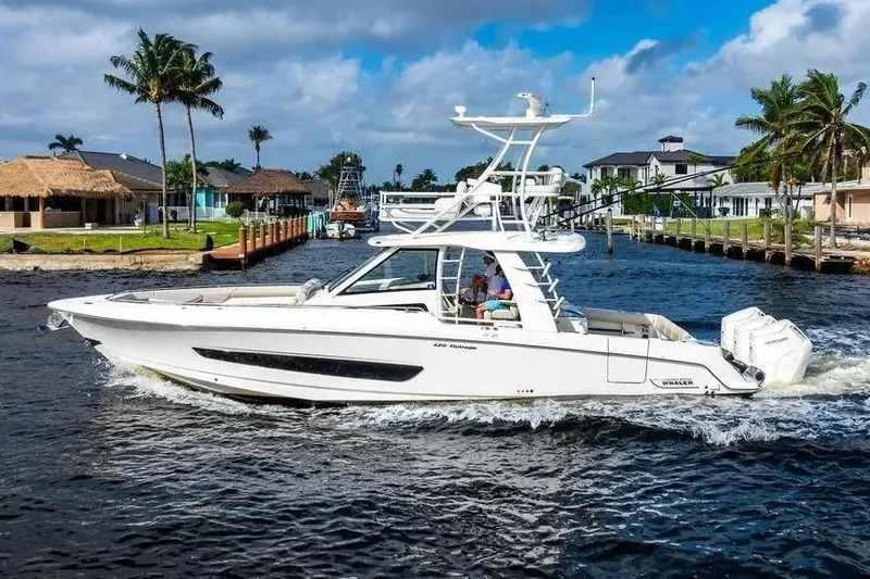  Yacht Photos Pics 2022 Boston Whaler 420 Outrage cruising on a scenic waterway with palm trees.