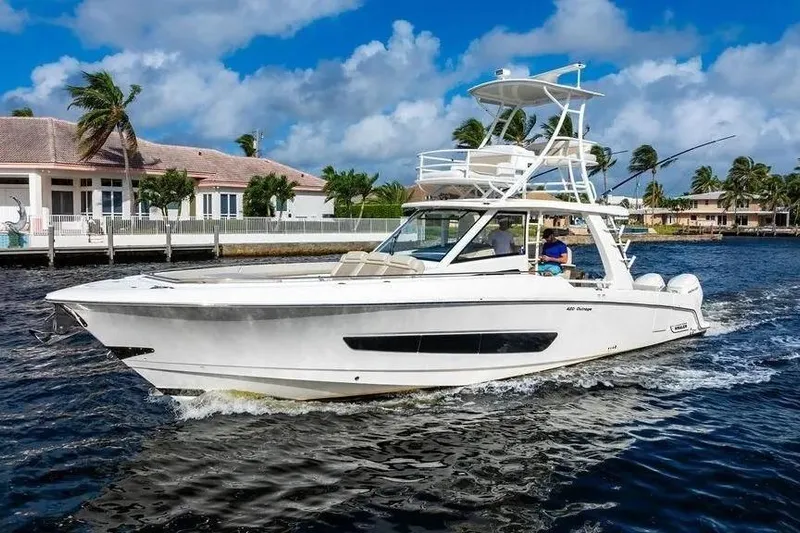  Yacht Photos Pics 2022 Boston Whaler 420 Outrage cruising on a sunny day near waterfront homes.
