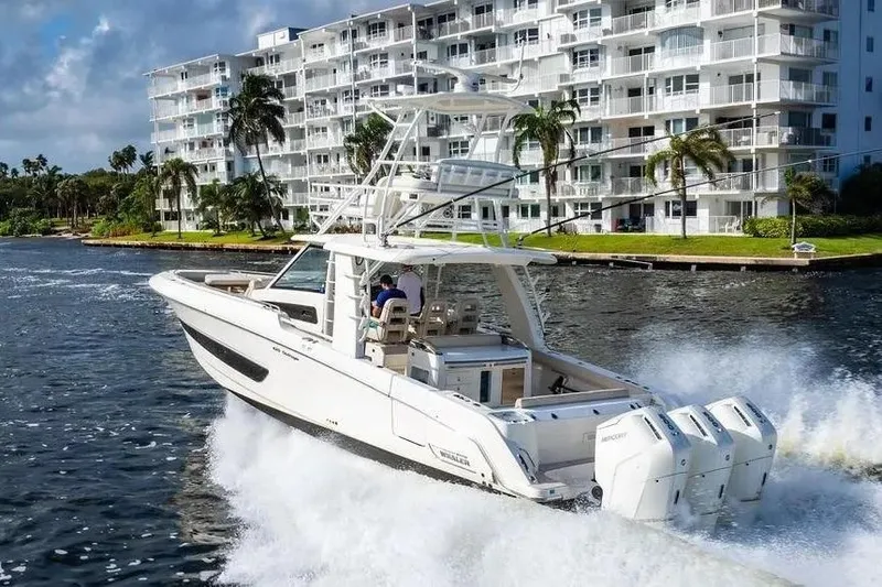  Yacht Photos Pics 2022 Boston Whaler 420 Outrage cruising near waterfront buildings.