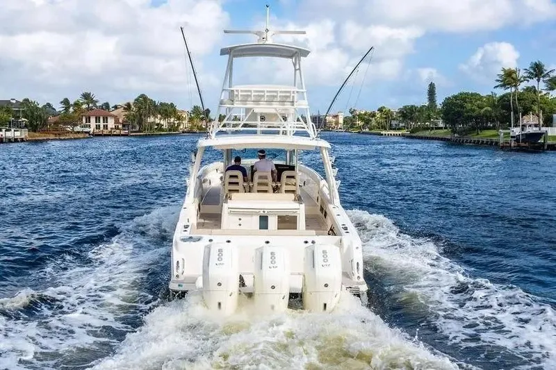  Yacht Photos Pics 2022 Boston Whaler 420 Outrage cruising on a scenic waterway with palm trees.