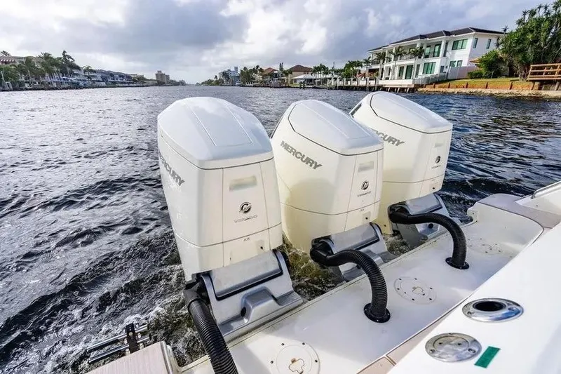  Yacht Photos Pics 2022 Boston Whaler 420 Outrage with triple Mercury outboard engines on a scenic waterway.