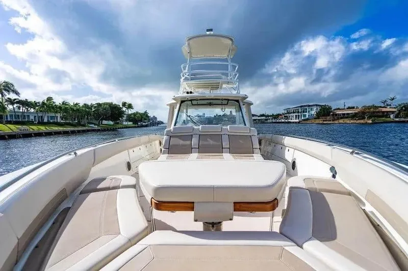  Yacht Photos Pics Boston Whaler 420 Outrage 2022 on a scenic waterway, showcasing luxury seating and sleek design.