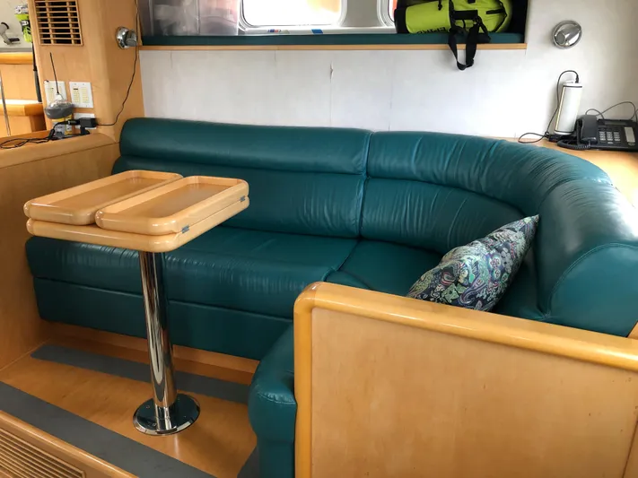Evening Star Yacht Photos Pics Luxurious interior of a 2003 Cape Horn Trawler with teal seating and wooden table.