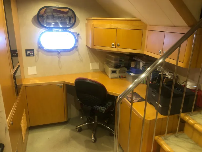 Evening Star Yacht Photos Pics Office space inside a 2003 Cape Horn Trawler, featuring wooden cabinetry and a porthole window.