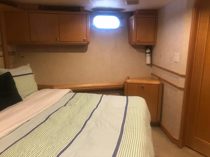 Evening Star Yacht Photos Pics Cozy bedroom interior of 2003 Cape Horn Trawler with wood cabinets and striped bedding.