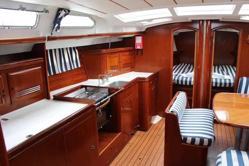 Yacht Photos Pics Interior of 2003 Beneteau Oceanis Clipper 473 yacht with wood finish and striped upholstery.