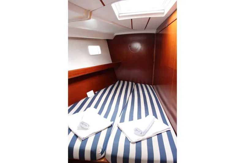  Yacht Photos Pics Cozy cabin interior of 2003 Beneteau Oceanis Clipper 473 with striped bedding.