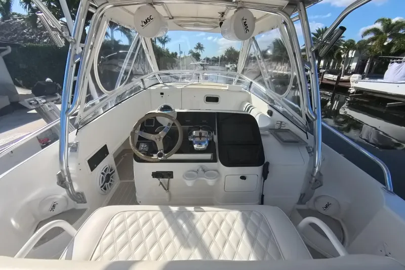  Yacht Photos Pics 2005 Intrepid 348 Walkaround boat interior with steering wheel and seating, docked by palm trees.