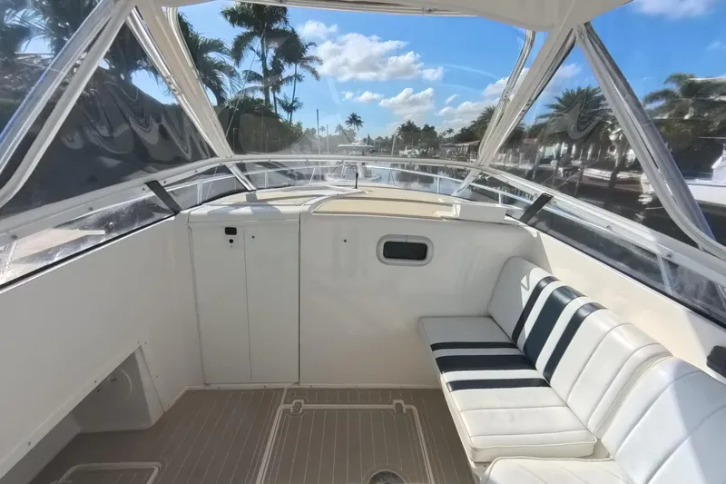  Yacht Photos Pics 2005 Intrepid 348 Walkaround boat interior with seating, clear skies, and palm trees.