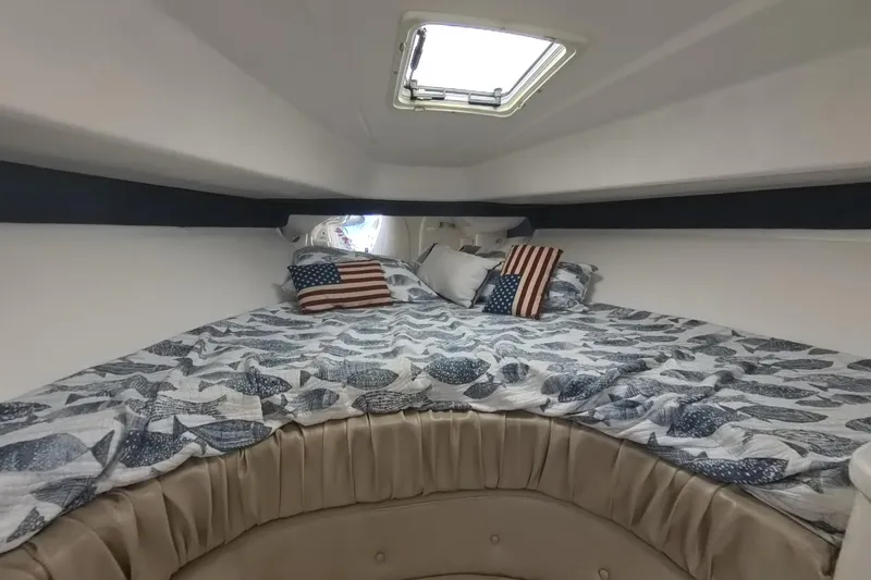  Yacht Photos Pics Cozy cabin interior of 2005 Intrepid 348 Walkaround with nautical-themed bedding and American flag pillows.