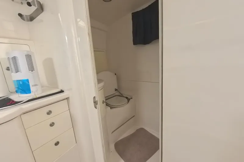  Yacht Photos Pics 2005 Intrepid 348 Walkaround boat bathroom with white cabinetry and compact toilet.
