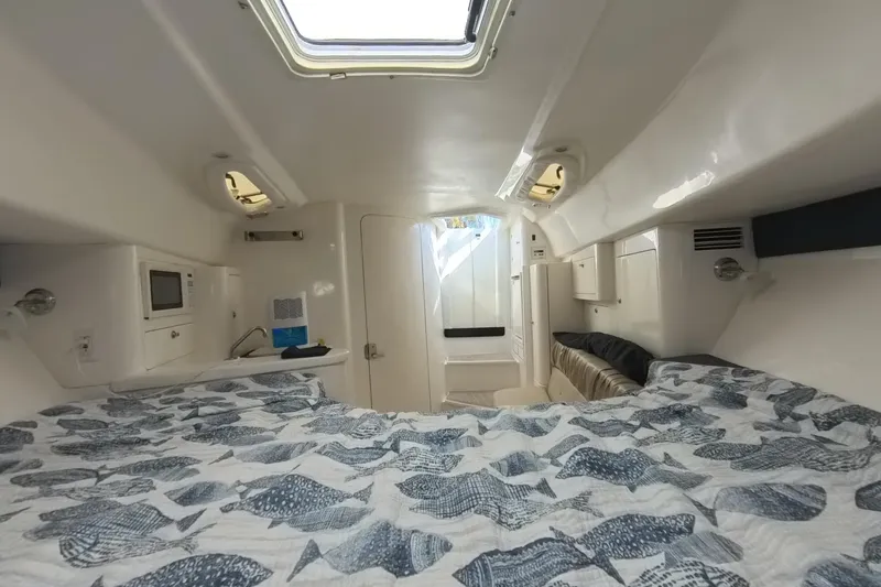  Yacht Photos Pics Interior of a 2005 Intrepid 348 Walkaround boat, featuring a cozy cabin with a bed.