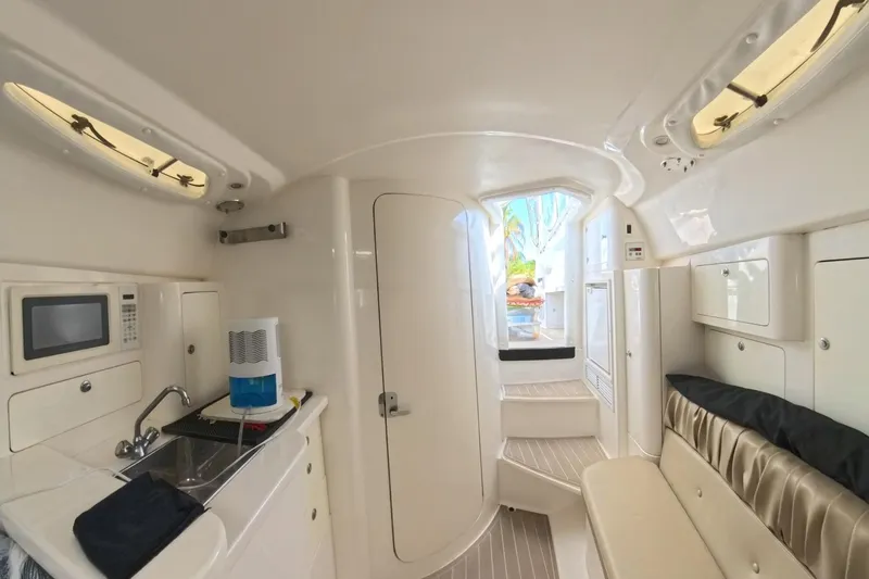  Yacht Photos Pics Interior of 2005 Intrepid 348 Walkaround boat with kitchenette and seating area.