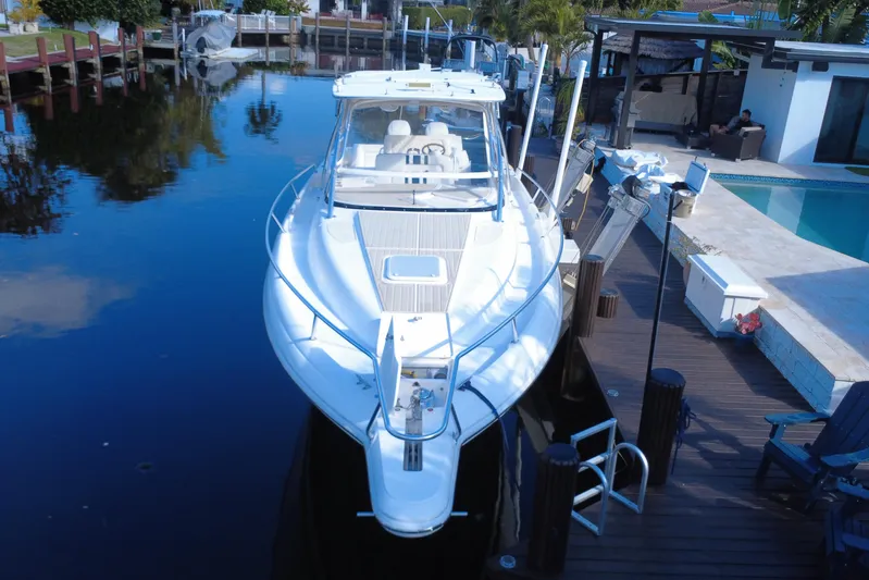  Yacht Photos Pics 2005 Intrepid 348 Walkaround boat docked by a poolside in a serene setting.