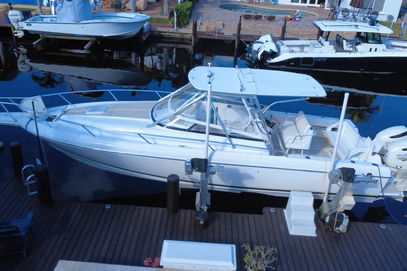  Yacht Photos Pics 2005 Intrepid 348 Walkaround boat docked at a marina, featuring sleek design and spacious deck.