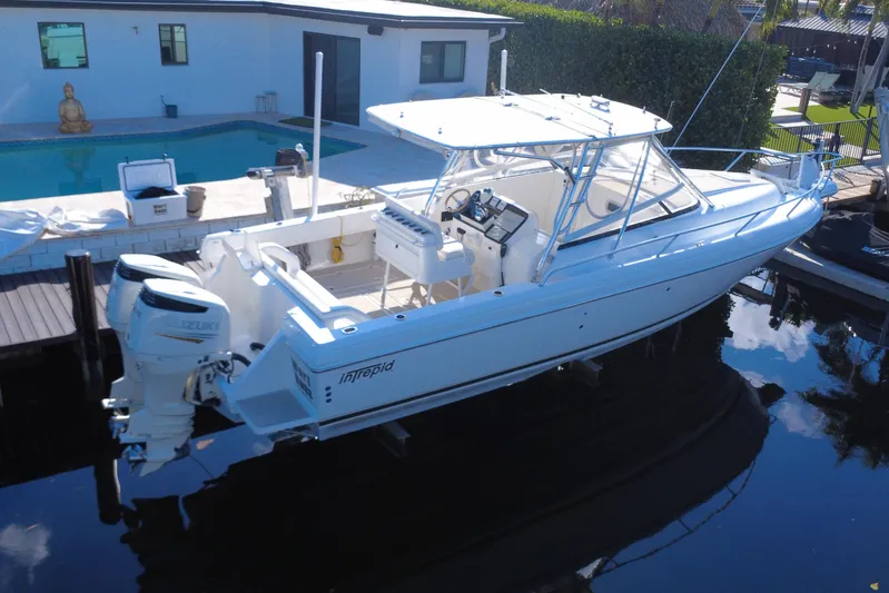  Yacht Photos Pics 2005 Intrepid 348 Walkaround boat docked near a poolside, featuring dual Suzuki engines.