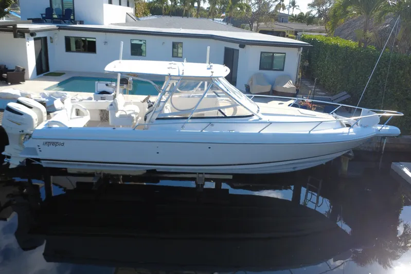  Yacht Photos Pics 2005 Intrepid 348 Walkaround boat docked near modern waterfront home.
