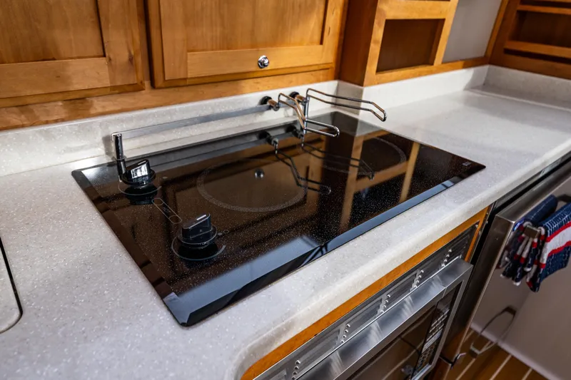 Big Blue Yacht Photos Pics Modern kitchen in 2010 Back Cove 37 yacht with sleek stovetop and wooden cabinetry.