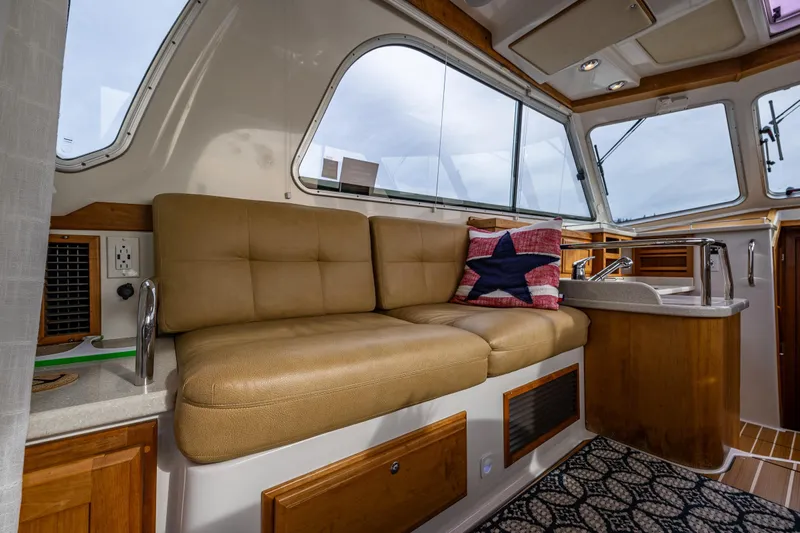 Big Blue Yacht Photos Pics Interior of 2010 Back Cove 37 yacht with beige seating and star-patterned pillow.