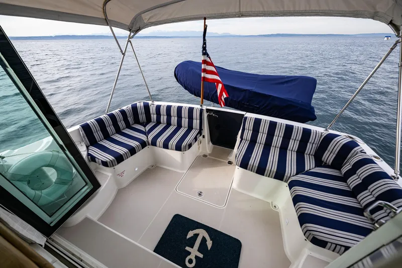 Big Blue Yacht Photos Pics 2010 Back Cove 37 boat with striped seating, American flag, and ocean view.