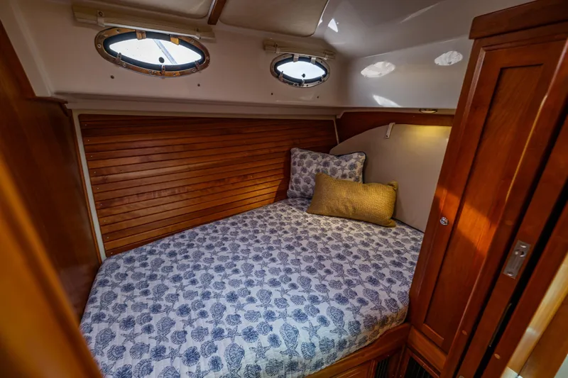 Big Blue Yacht Photos Pics Cozy cabin interior of 2010 Back Cove 37 boat with wooden accents and patterned bedding.