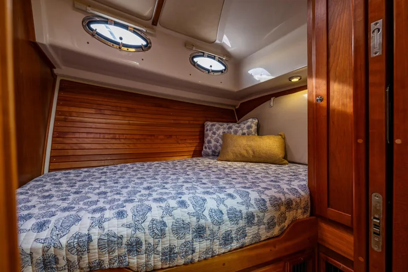 Big Blue Yacht Photos Pics Cozy cabin interior of 2010 Back Cove 37 boat with wooden accents and nautical bedding.