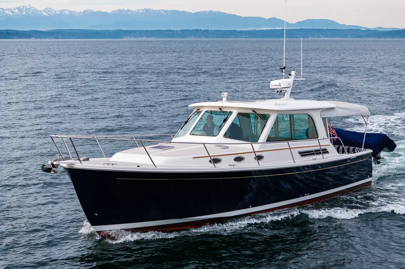 Big Blue Yacht Photos Pics 2010 Back Cove 37 yacht cruising on open water with scenic mountain backdrop.