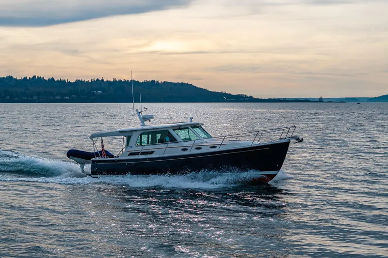 Big Blue Yacht Photos Pics 2010 Back Cove 37 cruising on a serene lake at sunset.