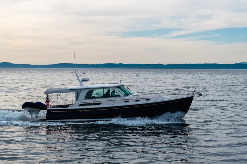 Big Blue Yacht Photos Pics 2010 Back Cove 37 yacht cruising on calm waters under a cloudy sky.