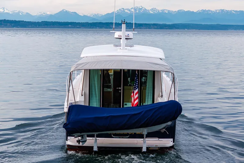 Big Blue Yacht Photos Pics Back Cove 37 boat cruising on calm waters with mountain backdrop, 2010 model.