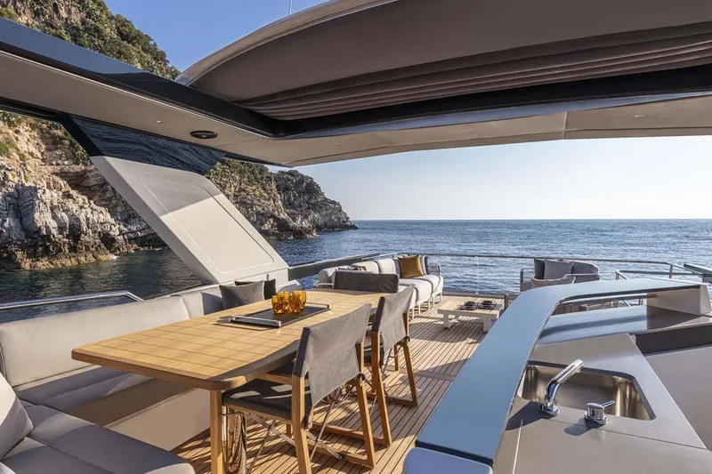  Yacht Photos Pics Manufacturer Provided Image: Luxurious 2022 Absolute 64 Navetta yacht with elegant outdoor dining area and stunning sea view.