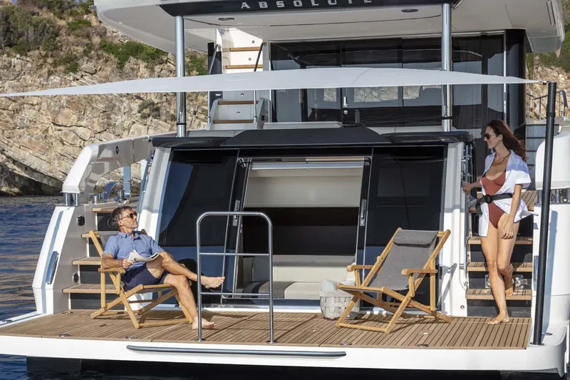  Yacht Photos Pics Manufacturer Provided Image: 2022 Absolute 64 Navetta yacht with people relaxing on the deck.
