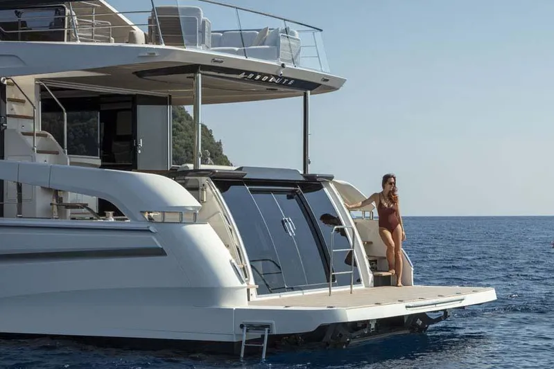  Yacht Photos Pics Manufacturer Provided Image: 2022 Absolute 64 Navetta yacht with a woman standing on the swim platform.