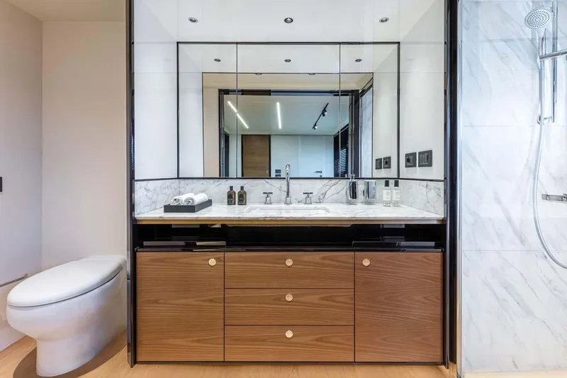  Yacht Photos Pics Manufacturer Provided Image: Luxury bathroom in 2022 Absolute 64 Navetta yacht with modern fixtures and wooden cabinetry.