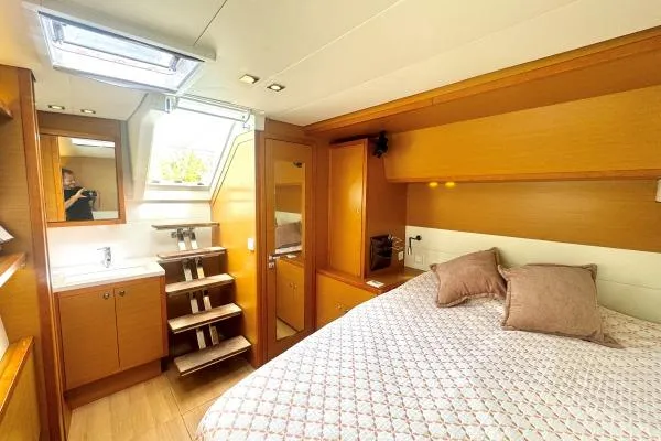 Nauti Adventure Yacht Photos Pics Luxurious cabin interior of 2015 Lagoon 52 F yacht with cozy bed and wooden furnishings.