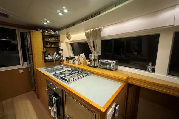 Nauti Adventure Yacht Photos Pics Modern kitchen interior on a 2015 Lagoon 52 F yacht, featuring appliances and ample counter space.