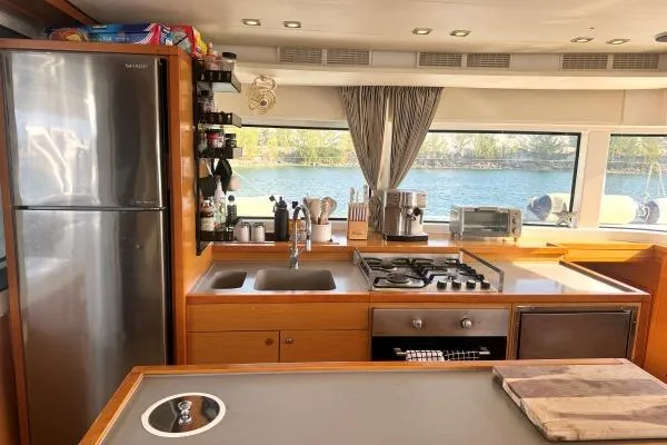 Nauti Adventure Yacht Photos Pics Modern kitchen interior of 2015 Lagoon 52 F yacht with appliances and scenic window view.