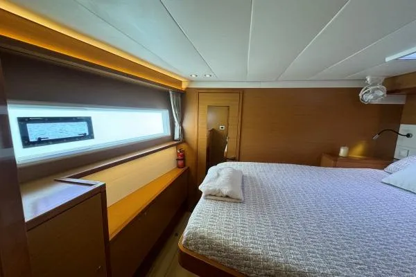 Nauti Adventure Yacht Photos Pics Luxurious cabin interior of 2015 Lagoon 52 F yacht with cozy bed and window view.
