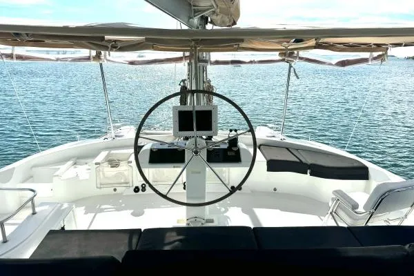 Nauti Adventure Yacht Photos Pics Cockpit view of 2015 Lagoon 52 F catamaran with steering wheel and ocean backdrop.