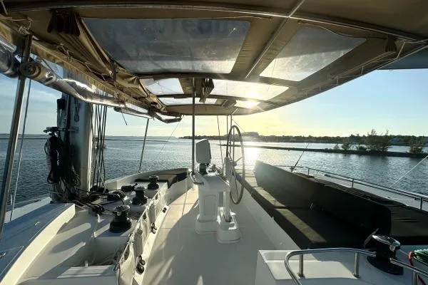 Nauti Adventure Yacht Photos Pics 2015 Lagoon 52 F yacht cockpit with steering wheel, overlooking serene water at sunset.