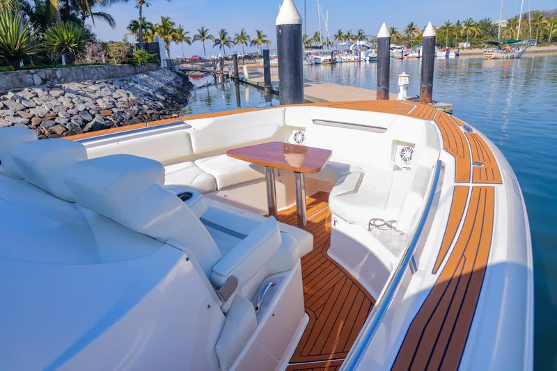 Oso Del Mar Yacht Photos Pics 2022 Tiara Yachts 43 LS with elegant seating and wooden deck in a marina setting.
