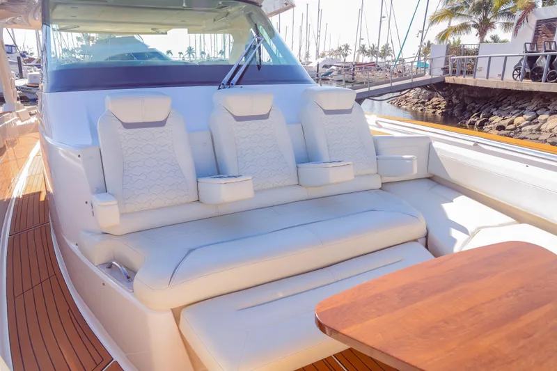 Oso Del Mar Yacht Photos Pics 2022 Tiara Yachts 43 LS luxury seating area with white upholstery and wooden table.