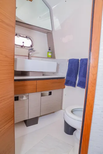 Oso Del Mar Yacht Photos Pics 2022 Tiara Yachts 43 LS bathroom with modern sink, mirror, and wooden cabinetry.