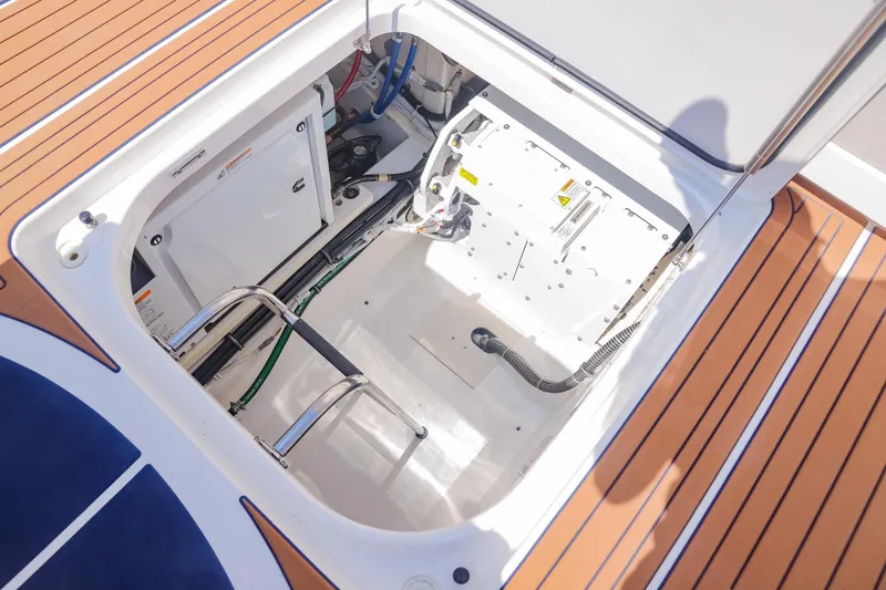 Oso Del Mar Yacht Photos Pics Engine compartment of 2022 Tiara Yachts 43 LS with teak flooring and visible machinery.