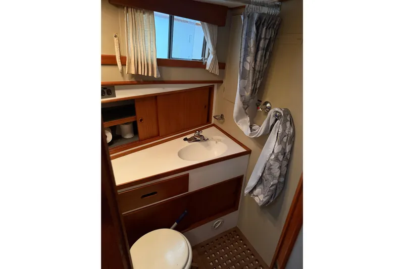  Yacht Photos Pics 1981 Grand Banks 42 Classic yacht bathroom with sink, toilet, and wooden cabinetry.