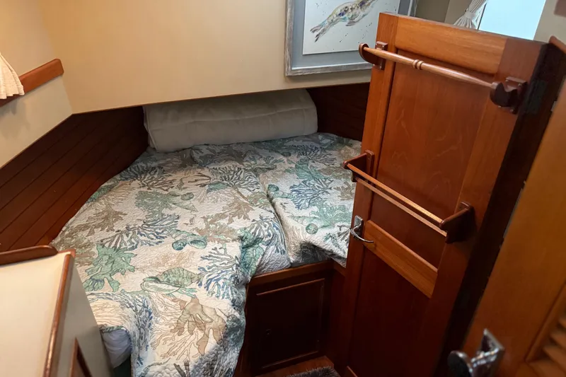  Yacht Photos Pics Cozy cabin interior of 1981 Grand Banks 42 Classic with nautical-themed bedding.